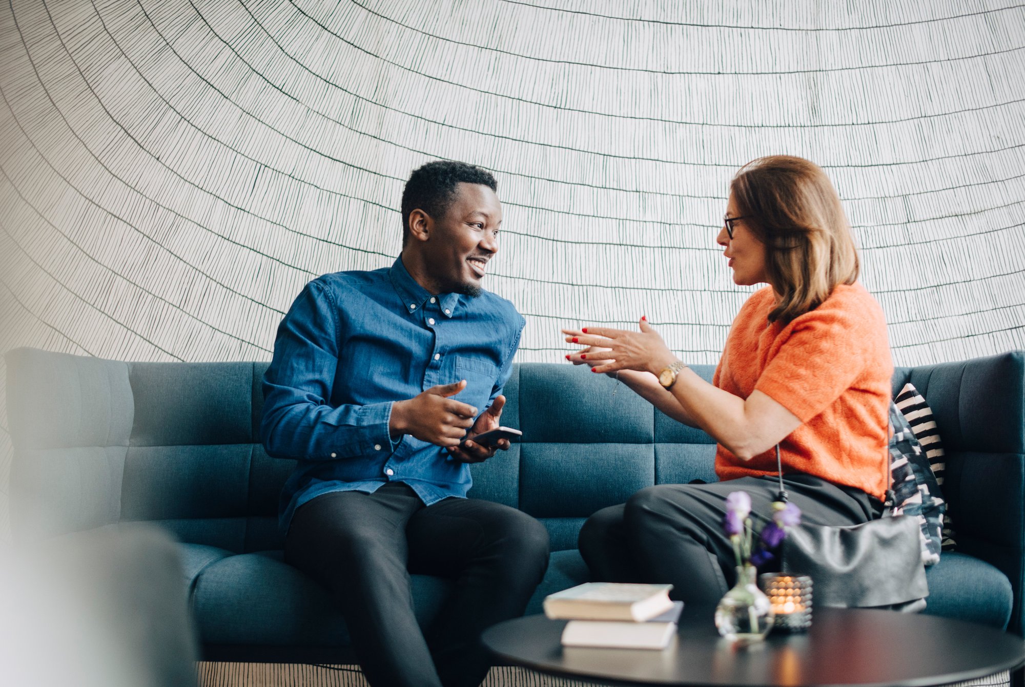 Two teachers talking while sitting on a sofa