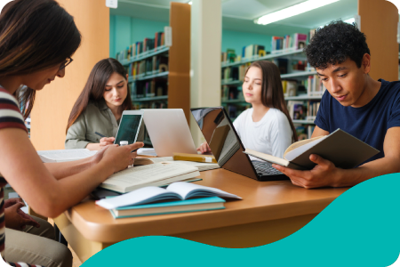 Students preparing an exam in a school library with books and computers