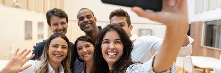 A group of smiling teacher taking a selfie.